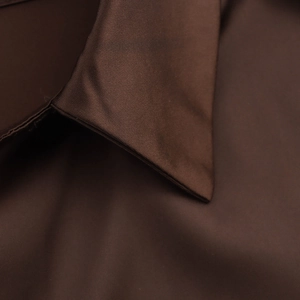 Vue détaillée du col de chemise en satin marron foncé avec texture de tissu satiné