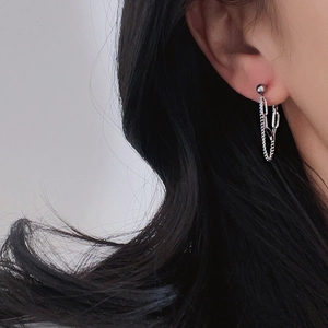 Close-up of double chain dangle earrings in polished silver on a female model