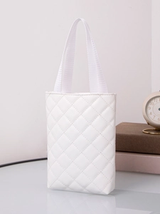 Detailed close-up of white quilted tote bag with soft fabric handles and woven texture