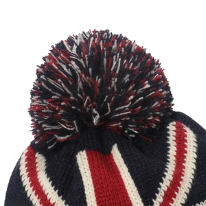 Dettaglio ravvicinato di un berretto in maglia tricolore con un grande pompon morbido