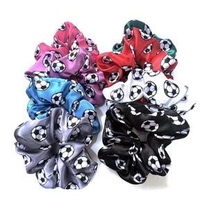 Detailed view of six colorful satin hair scrunchies with football patterns in a soft pack