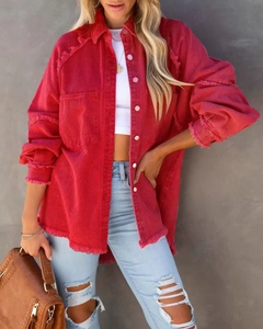 Detailed view of red denim jacket with frayed edges and dual pockets on female model