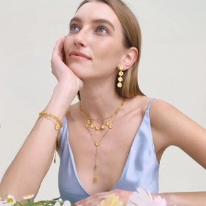 Détail de la parure collier et boucles d'oreilles fleur de marguerite dorée et zircons