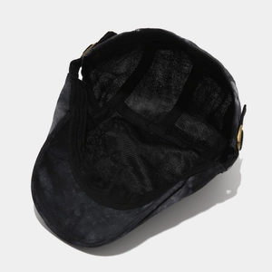 Detail of vintage tie-dye cotton flat cap showing interior sweatband and brass metal buckle