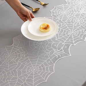 Nordic luxury white spider web table runner with intricate hollow lace on a grey tabletop
