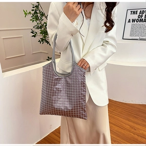 Detail der lila Strass-Tote-Bag mit glitzerndem Netzgewebe auf weißem Anzug