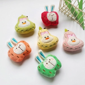 Detail of plush apple rabbit and pear duck pendants with colorful embroidery details