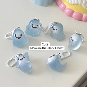 Set of six glowing cartoon ghost keychains in translucent light blue with cute expressions