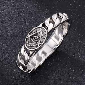 Detailed macro view of silver titanium steel Cuban link bracelet with Masonic eye emblem