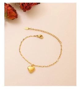 Detailed macro view of gold heart pendant bracelet with K18 engraving and lobster clasp