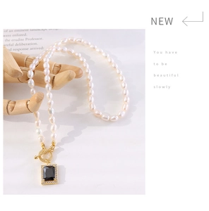 Detail of freshwater pearl necklace featuring black zircon pendant and gold OT clasp