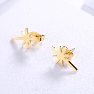 Close-up of gold star stud earrings with a polished finish on a white background