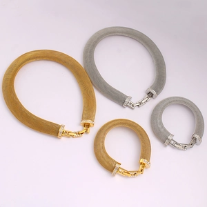Flat lay of luxury mesh chokers and bracelets in gold and silver with zircon accents