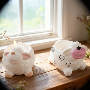 Cute sheep candle holder and planter set made of white resin on a sunny wooden windowsill
