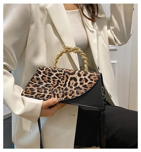 Detail of leopard print flap bag with unique gold twisted metal handle and textured leather