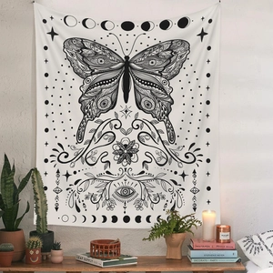Detail of bohemian tapestry featuring butterfly, moon phases and mystical eye patterns