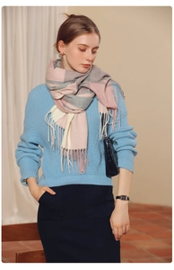 Detail shot of the pink, grey and beige plaid scarf with soft fringe tassels on the ends