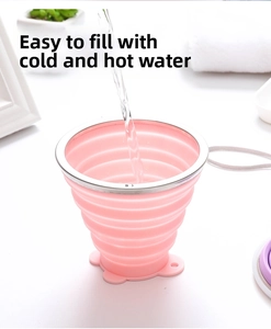 Pink silicone folding cup with water being poured, showing heat resistance and detail