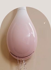 Detail of pink wall-mounted toilet brush holder with drainage slot for ventilation