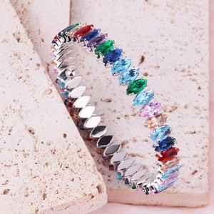 Elegant silver bracelet with multi-color marquise-cut crystals on beige stone background
