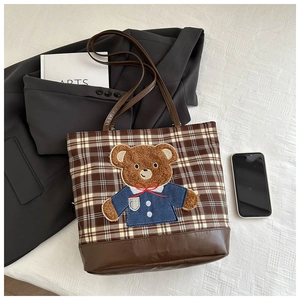 Detail of checkered wool tote bag featuring a cute 3D bear embroidery and leather straps