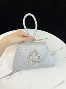 Detail der silbernen Glitzer-Abendtasche mit ovaler Kristallschnalle und Ringgriff