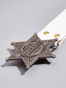 Close-up of vintage metal star buckle with Sheriff engraving on white punk style belt