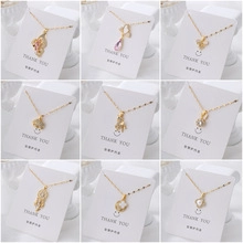 Detail of nine micro-set zircon gold-plated pendants including butterfly and floral designs