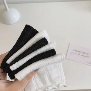 Detail of folded lace mesh mid-calf socks in black and white with ruffled edges