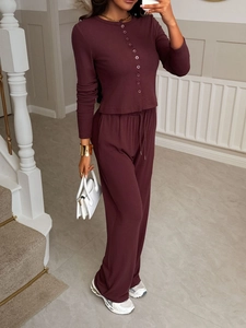 Close-up of women's burgundy two-piece set featuring button-up shirt and wide-leg trousers