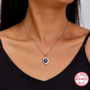 Detail view of a 925 sterling silver necklace with a black pearl pendant on a model