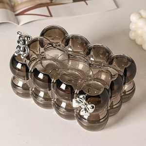 Gray transparent bubble tissue box with silver bear and bow on cream tabletop