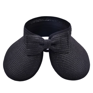Detail showing the fine woven texture and decorative black bow of the straw sun visor hat
