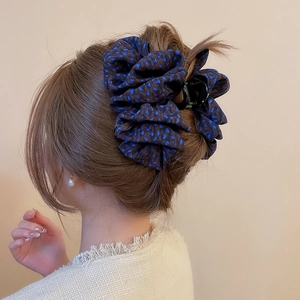 Détail de la pince à cheveux en tissu léopard portée par un mannequin pour chignon