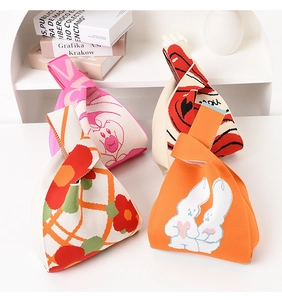 Close-up of four knitted wrist bags with cute rabbit patterns and floral designs