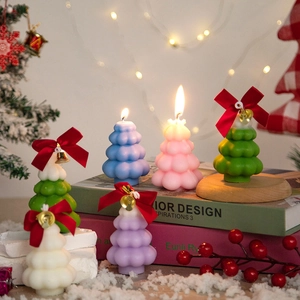 Set of six colorful Christmas tree scented candles with bows on a festive background