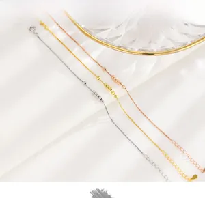 Macro view of silver and gold plated box chain bracelet featuring five polished beads