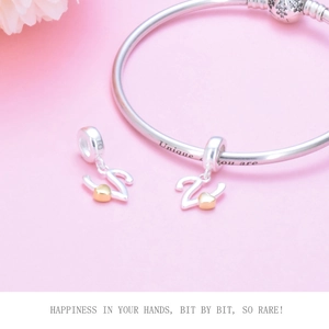 Detail of silver S925 charms with gold hearts on a snake chain bracelet
