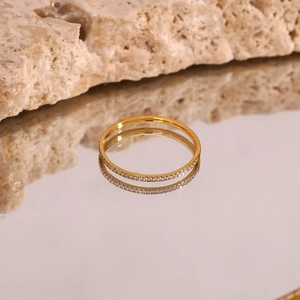 Macro detail of gold eternity ring with micro-paved zircons on a reflective surface