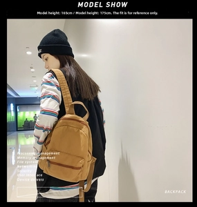 Brauner Canvas-Mini-Rucksack am Modell gezeigt, betont Größe und lässigen Look