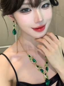 Close-up of green teardrop zircon necklace and earrings set worn by a fashion model