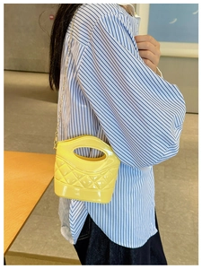 Dettaglio della mini borsa a secchiello gialla trapuntata con catena dorata