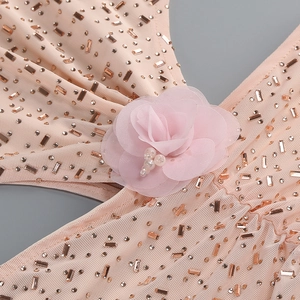 Détail de robe de gala rose avec fleurs en mesh 3D, strass or rose et perles
