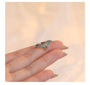 Close-up of adjustable S925 silver bow ring with sparkling green pavé zircon stones