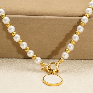 Elegante collana di perle e sfere dorate con pendente tondo in conchiglia e chiusura OT