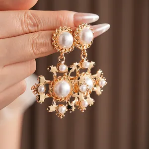 Orecchini vintage con croce dorata e perle in stile palazzo per donne vista da vicino