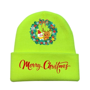 Detail of green knitted beanie featuring a festive Christmas wreath and Merry Christmas text