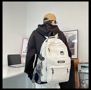 Dettaglio di uno zaino scolastico bianco capiente con tasche multiple ed etichetta