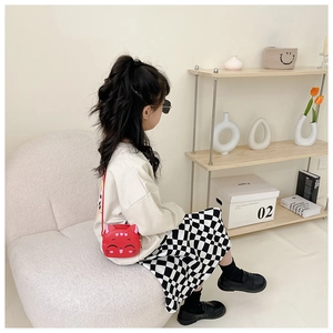Girl wearing a cute red cartoon cat crossbody bag made of PU leather and silicone
