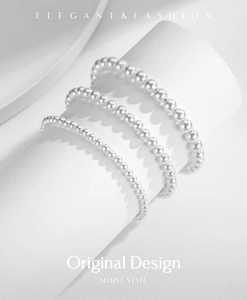 Detailed view of layered S925 sterling silver pearl bracelets in various pearl sizes
